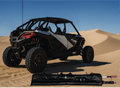 Off-road vehicle on sand dunes with a folded canopy in the foreground